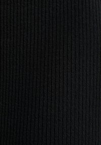 Tessuto a coste nero con un motivo verticale, caratterizzato da una superficie tessurizzata che trasmette una sensazione morbida. Adatto per diverse applicazioni nell'abbigliamento.
