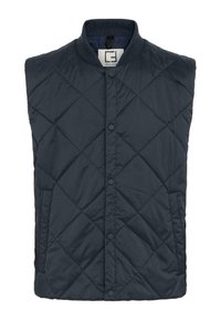 Mörk marinblå quiltad väst med diamantmönster, tryckknappar, ribbad krage och sidofickor. Tillverkad av lätt syntetmaterial.