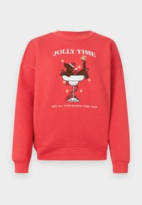 Κόκκινο φούτερ με κεντρικό σχέδιο ενός σκύλου σε μπολ με καπέλο του Άγιου Βασίλη και αστέρια. Το κείμενο γράφει "ΧΑΡΕΣ ΤΟΥ ΧΕΙΜΩΝΑ" και "ΕΥΧΟΜΑΙ ΟΛΕΣ ΟΙ ΕΥΧΕΣ ΣΟΥ ΝΑ ΓΙΝΟΥΝ ΠΡΑΓΜΑΤΙΚΟΤΗΤΑ."