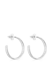 Pendientes de aro de plata con un acabado suave, que presentan un diseño troquelado a lo largo del borde y un cierre seguro para su uso.