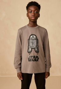 Szary t-shirt z długim rękawem, z grafiką R2-D2 oraz napisem "Star Wars" w kolorze czarnym. Wykonany z bawełny, posiada okrągły dekolt i luźny krój.