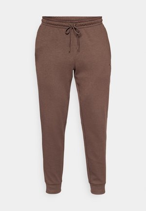 Pantalones de chándal marrones hechos de una tela suave, con cintura ajustable con cordón, puños acanalados y un diseño minimalista sin patrones visibles.