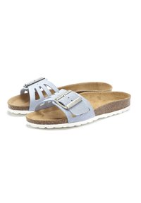 Light blue suede sandals with a wide strap, decorative cutouts, a silver buckle, and a brown cork footbed on a white rubber sole.