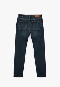 Vaqueros de denim azul oscuro con un corte ajustado, que cuentan con dos bolsillos traseros y una etiqueta de cuero marrón en la cintura. Diseño limpio y minimalista.
