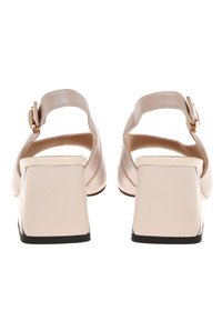 Sandales à talons carrés en cuir rose avec une finition lisse, une bride de cheville ajustable et des talons de forme carrée dotés d'un accent brillant.