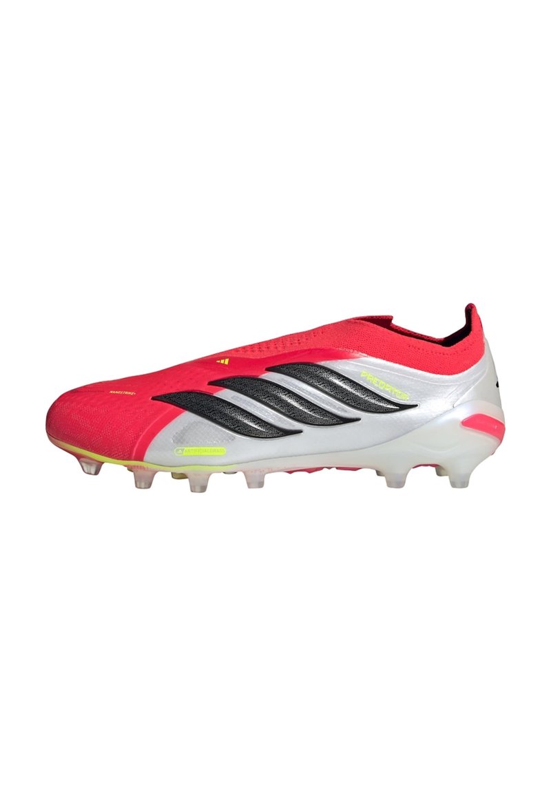Κόκκινο και άσπρο παπούτσι ποδοσφαίρου Adidas Predator με μαύρες ρίγες, νέον κίτρινες λεπτομέρειες και καρφιά για τεχνητά χλοοτάπητα.