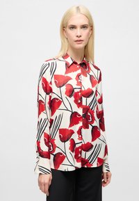 Blouse met lange mouwen, voorzien van een bloemenprint met rode klaprozen op een crèmekleurige achtergrond, met knoopsluiting aan de voorkant en een losse pasvorm.
