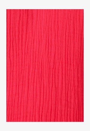 Tissu rouge vif avec une texture douce et froissée et de fines rides verticales sur toute la surface.