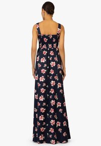 Maxikleid aus navyfarbener Baumwolle mit floralem Muster in Pink und Weiß. Quadratischer Ausschnitt, breite Träger und ein gerafftes Rücken-Detail.