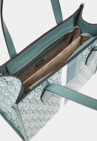 Taška přes rameno v mátově zelené syntetické materiálu s geometrickým vzorem, zapínáním na zip, dvojitými rukojetmi a několika vnitřními přihrádkami.