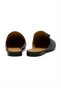 Sandali slide in pelle verde con design aperto sul retro, silhouette minimalista e suola piatta in gomma nera con soletta color tan.