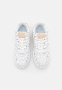 Białe trampki z perforowanym czubkiem, jasnoniebieskim wnętrzem i beżowymi akcentami na języku oraz pięcie. Posiadają plecione sznurowadła i logo.