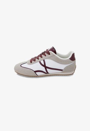 Sneakers in beige suede and white leather, featuring burgundy accents, lace-up design, and a textured rubber sole. Lightweight and sporty.