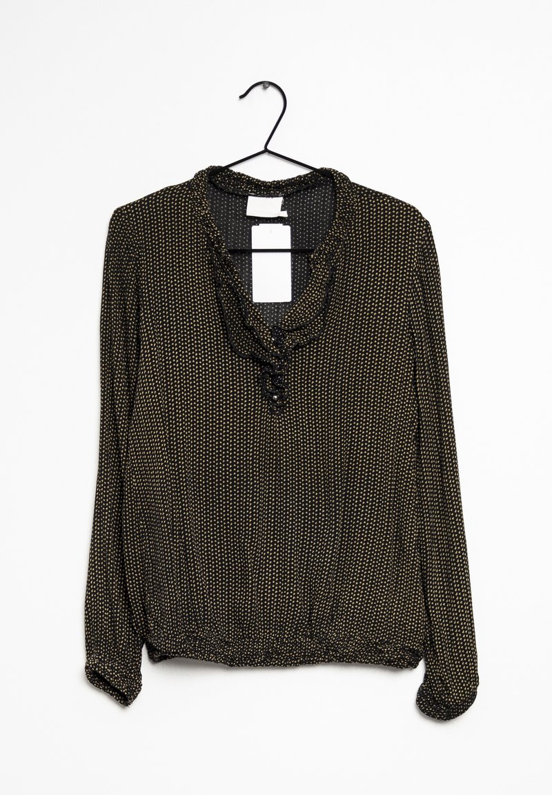 Blouse noire avec des pois dorés, décolleté froncé et un détail de bouton. Manches longues avec ourlet froncé, suspendue à un crochet noir.