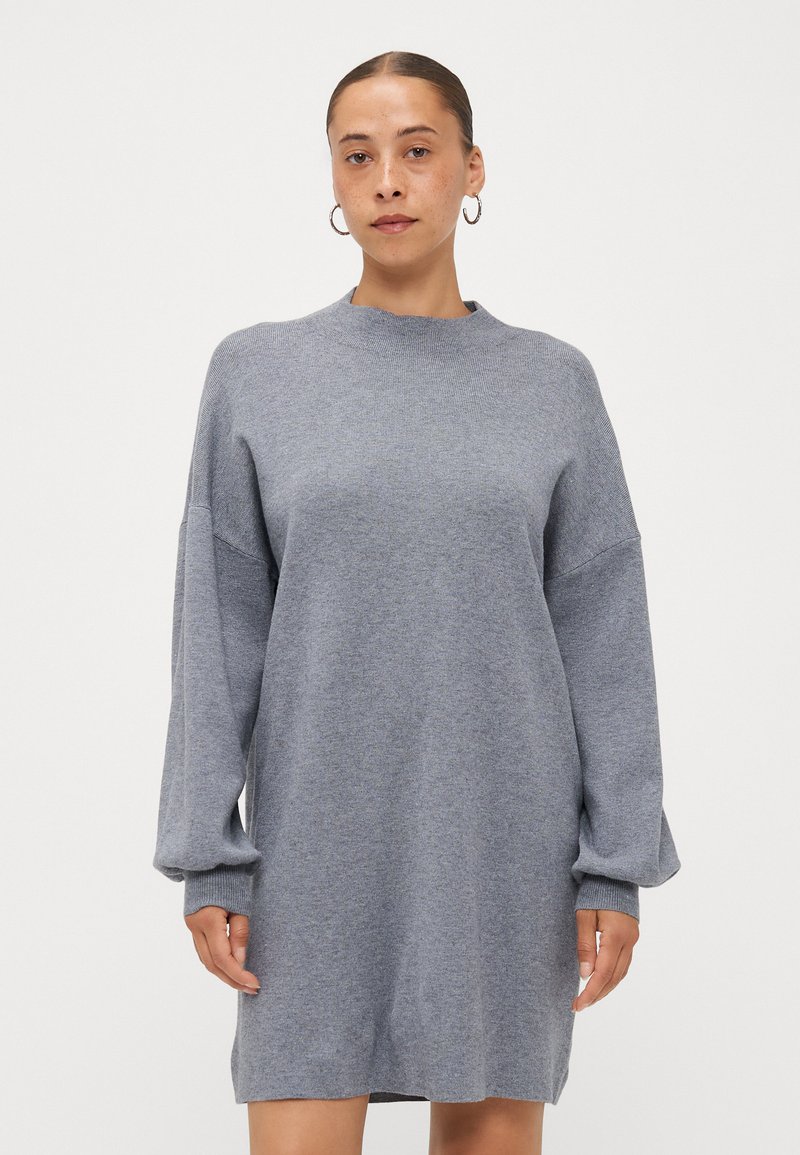 Grey knitted dress with long, loose sleeves and a high neckline. Soft texture, above-the-knee length, and subtle ribbing details.