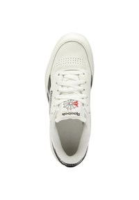 White leather sneaker with a round toe, perforated design, white laces, and black accents. Logo on tongue and heel. Soft interior lining.