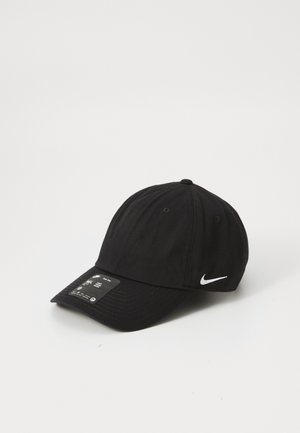 Zwarte Nike honkbalpet met een wit swoosh-logo aan de zijkant en een maatlabel op de klep, afgebeeld tegen een effen witte achtergrond.