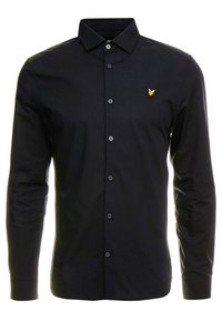 Zwarte blouse met lange mouwen, gemaakt van gladde stof, voorzien van een klassieke kraag en een klein geel logo op de linkerborst.