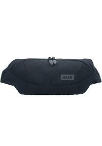 Schwarze, oval geformte Tasche aus Stoff mit Doppelreißverschluss und dezentem Logo. Glatte Textur mit minimalistischem Design.