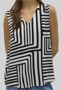 Top senza maniche bianco e nero con scollatura a V, caratterizzato da un motivo geometrico di linee striate di varie larghezze su un tessuto liscio.