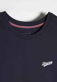 Granatowa koszulka z krótkim rękawem wykonana z bawełny, z okrągłym dekoltem, w czerwono-białe paski wewnętrznej kołnierza oraz białym logo "Diverse" na piersi.