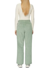 Lichtgroene Corduroy wijde broek met achterzakken, met een gestructureerd oppervlak en een hoge taille. Gepaard met een wit longsleeve shirt.