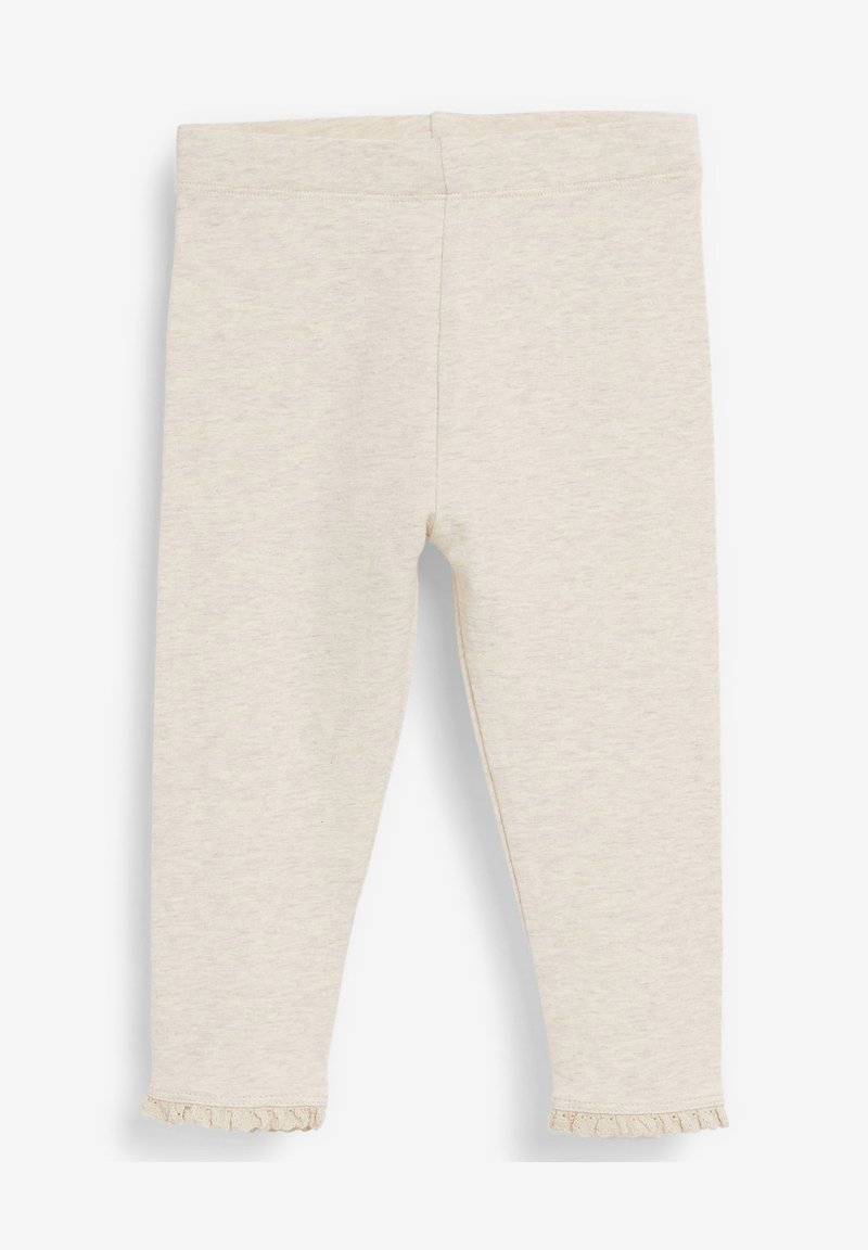 Lichtbeige legging gemaakt van zacht materiaal met een rekbare tailleband en een kleine geschulpte zoom bij de enkel. Gladde textuur zonder patronen.