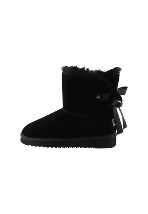 Stivaletto alla caviglia in camoscio nero con fodera in pelliccia morbida, suola piatta e nastro decorativo annodato a fiocco sul retro.