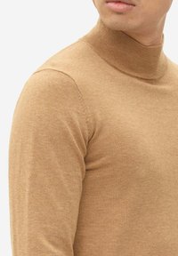 Beige turtleneck sweater made from soft knit material. Features a ribbed collar and fitted shape, with a smooth texture and minimal seams.