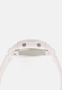Montre rose clair avec un bracelet en silicone texturé, dos en acier inoxydable et deux boutons argentés sur le côté. Design de boîtier octagonal.