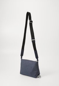 Blå stoff skulderveske med justerbar svart stropp, glidelåslukking og forsterkede hjørner. Har minimalistisk design og sølvfarget tilbehør.