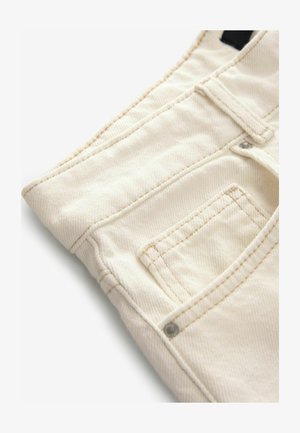 Kreemitooni teksapüksid tekstureeritud pinnaga, millel on väike esipocket ja kontrastsed õmblusdetailid. Ideaalne igapäevaseks kandmiseks.