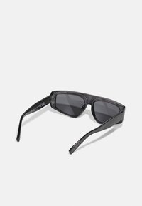 Gafas de sol con montura rectangular, hechas de plástico negro, con lentes oscuros y brazos elegantes y ligeramente curvados.