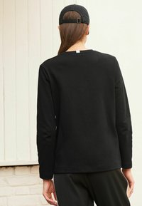 Zwarte langemouwen t-shirt met een regular fit en ronde hals, gemaakt van gladde katoenstof, met een eenvoudig ontwerp en geen zichtbare patronen.
