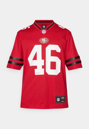 Camisa de la NFL roja con el número 46 en blanco, franjas negras en las mangas, logo del equipo en el pecho y una pequeña etiqueta en la parte inferior. Material de poliéster.