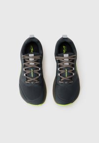 Un paio di scarpe da trekking nere e verde neon con lacci grigi su uno sfondo bianco, viste dall'alto.