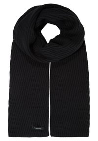 Écharpe tricotée noire à côtes, pliée avec une étiquette Calvin Klein visible à une extrémité sur fond blanc.