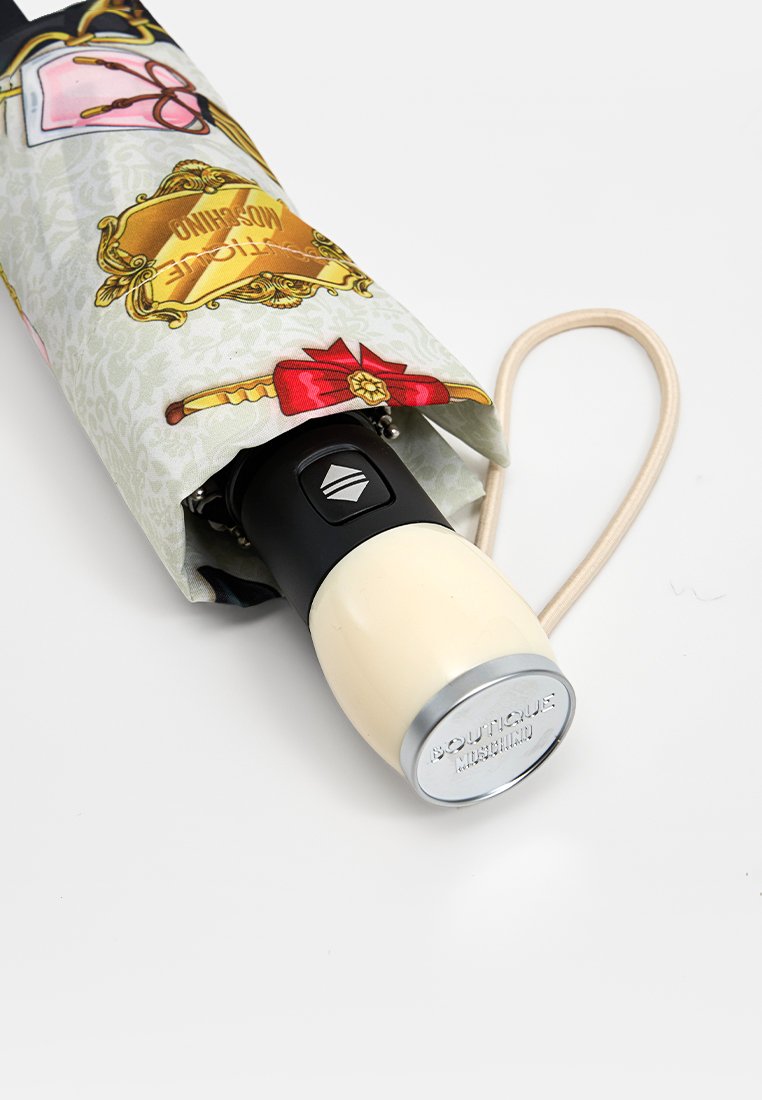 Paraguas compacto con una funda de tela estampada que presenta varios diseños. Mango negro con un agarre de color claro y un detalle base plateado.