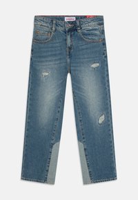 Lys blå denimjeans med avslappet passform, med slitte detaljer og en kontrasterende lys blå panel på nedre ben.