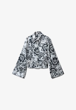 Kurz geschnittene Jacke im schwarz-weißen Blumenmuster, mit spitzem Kragen, Knopfverschluss und weiten Ärmeln. Glatte, glänzende Stoffoberfläche.