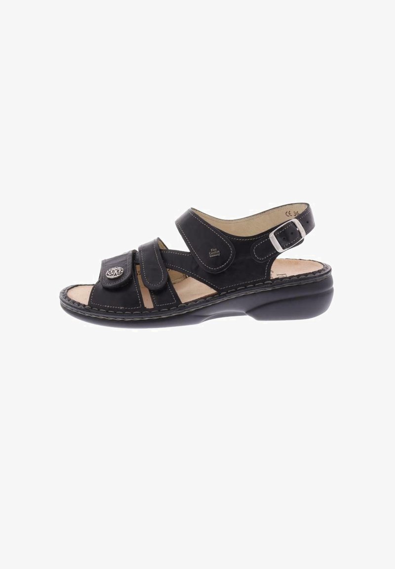 Sandalo in pelle nera con due fasce regolabili in Velcro, una fascia alla caviglia con fibbia in metallo e una soletta imbottita.