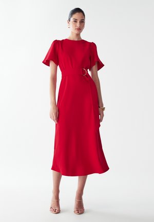 Rød, mellemlang kjole med korte flæser, rund halsudskæring og taljebælte med en cirkulær spænde. Glat tekstur.