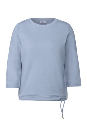 Ljusblå sweatshirt med rund halsringning, trekvartsärmar och sidodragkedjor för justerbar passform. Slät tygtextur.