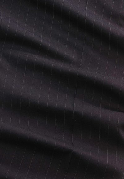 Tissu sombre avec de subtiles rayures verticales fines et des plis doux créant des ombres légères sur la surface.