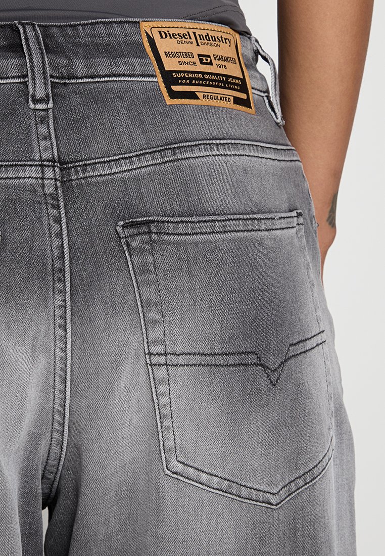 Jeans in denim grigio con un lavaggio distintivo, dotati di un'etichetta in pelle nella parte posteriore della vita con dettagli del marchio e due tasche posteriori con accenti di cucitura.