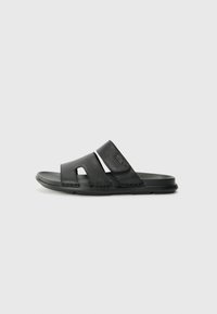 Black slide sandals with two textured straps featuring cutouts, a soft footbed, and a flexible rubber sole.