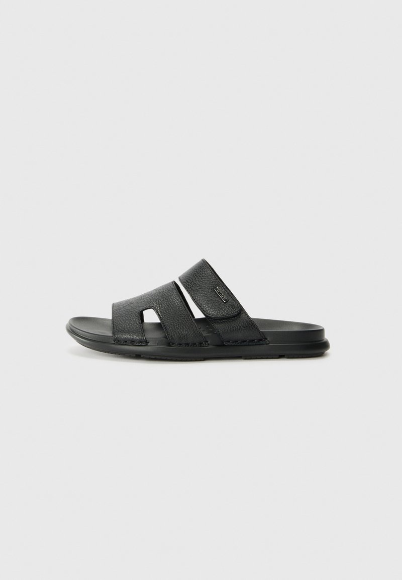 Black slide sandals with two textured straps featuring cutouts, a soft footbed, and a flexible rubber sole.