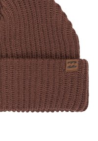 Beanie marrone lavorato a maglia con texture a costine, dotato di un orlo ripiegato e una piccola etichetta logata rettangolare sul lato.