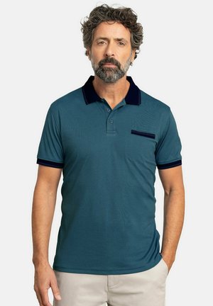 Camisa polo en color azul verdoso con cuello y acentos en las mangas en navy, que cuenta con un bolsillo en el pecho y una tapeta de tres botones. Tejido suave y ligero.