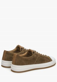 Brązowe zamszowe sneakersy z białymi gumowymi podeszwami, z gładkim tenkim skórzanym akcentem na pięcie i białymi sznurowadłami. Okrągły kształt nosa.